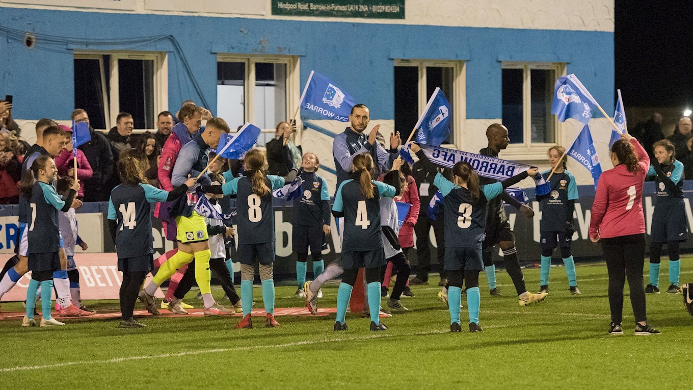A photograph of flag bearers welcoming the Barrow team to the pitch for the FA Cup replay against Ipswich Town