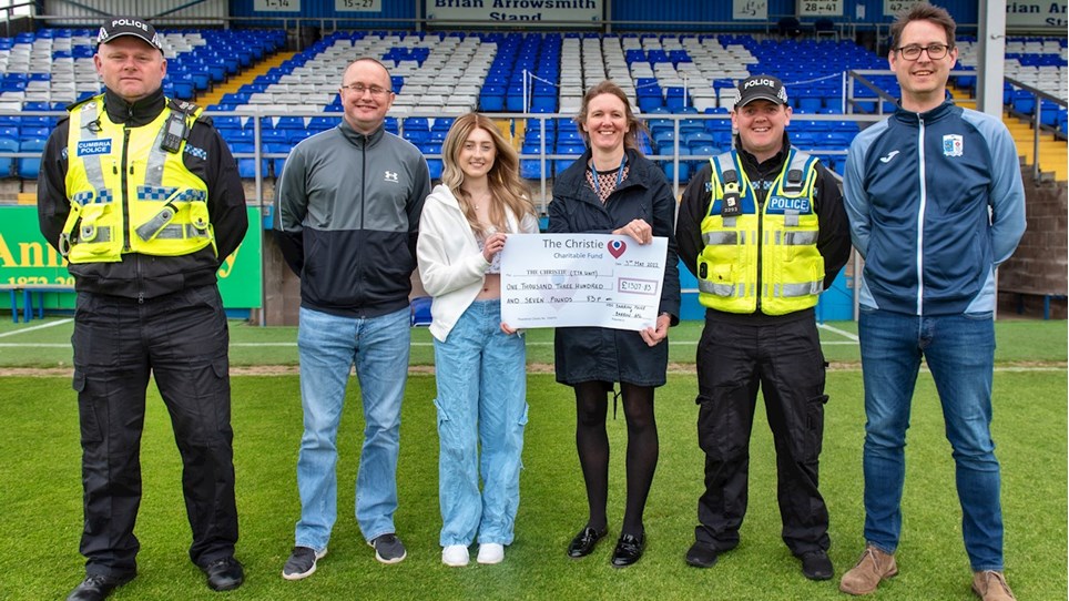 A photograph of Sgt John Dilks, Tracy Caldwell and Dave Pointer presenting a cheque to DC Scott Elliott and Maddison