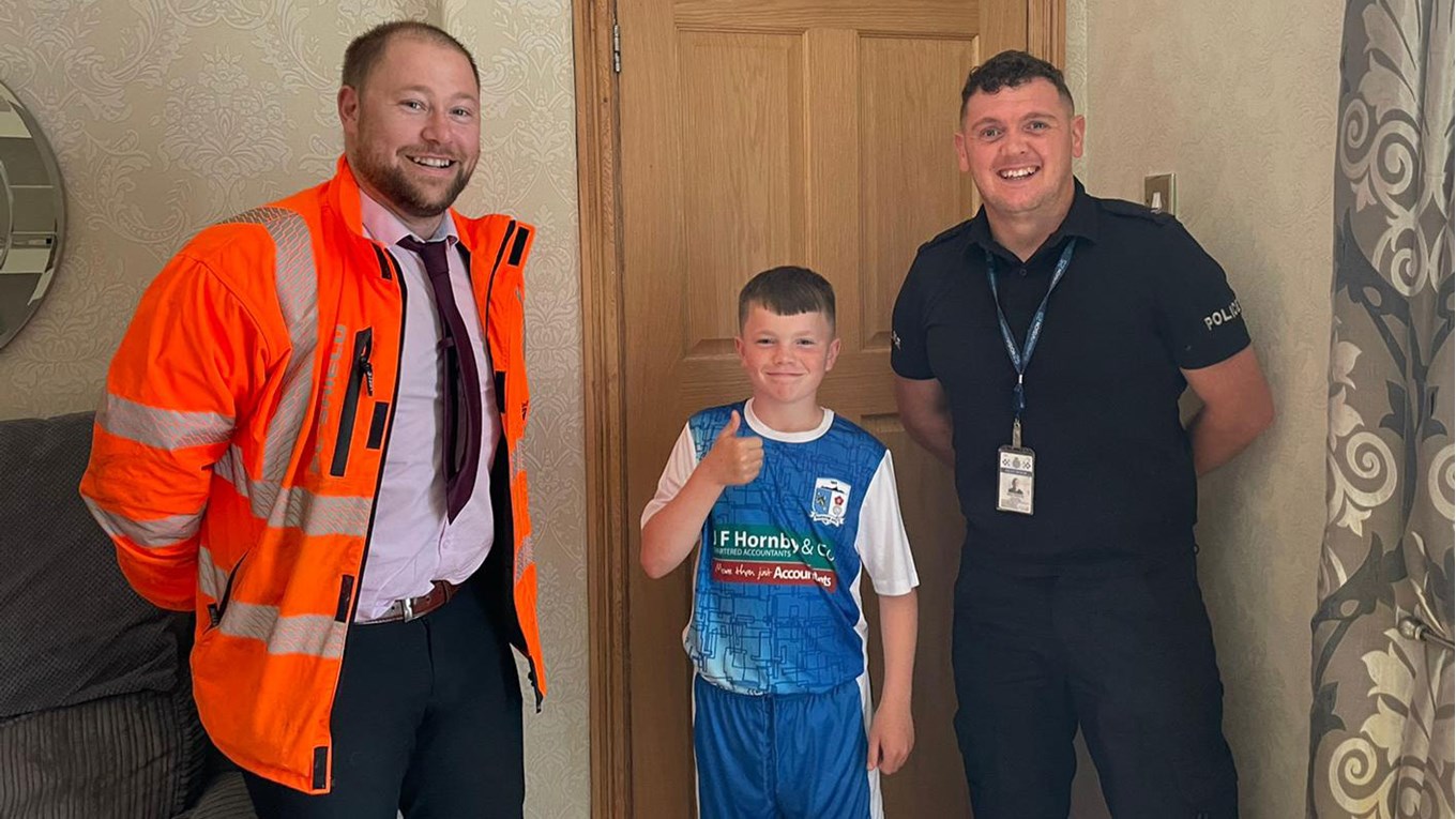 A photograph of Chris Altree and PC Rickie Wallbank with young Barrow fan, Jaxon