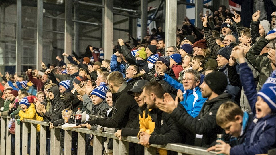 A photograph of Barrow fans celebrating at The Dunes Hotel Stadium