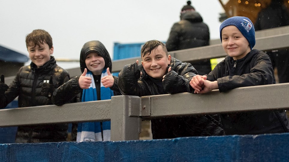A photograph of a group of young Barrow supporters at The Dunes Hotel Stadium
