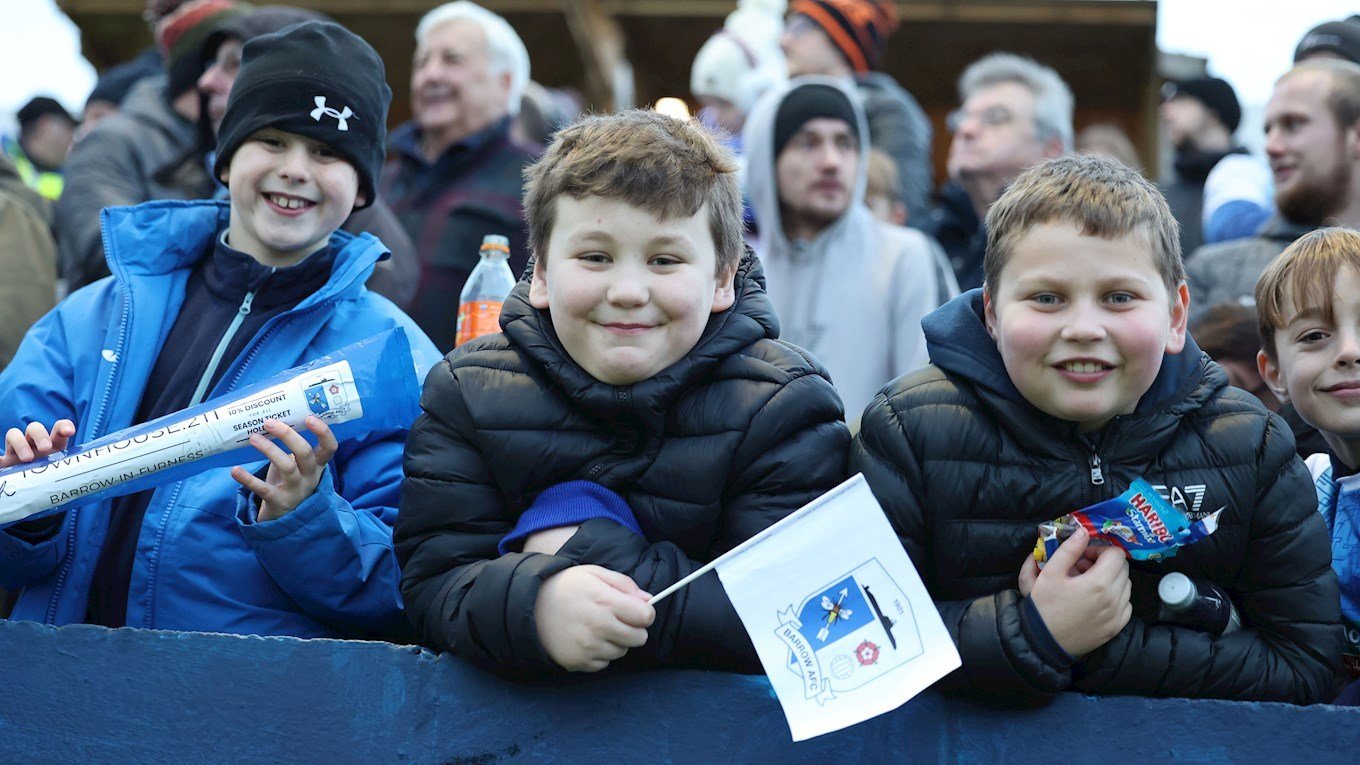 A photograph of young Barrow supporters at The Dunes Hotel Stadium