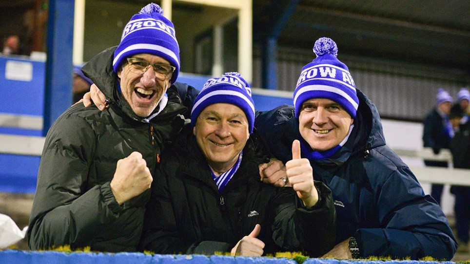 A photo of three Barrow fans celebrating
