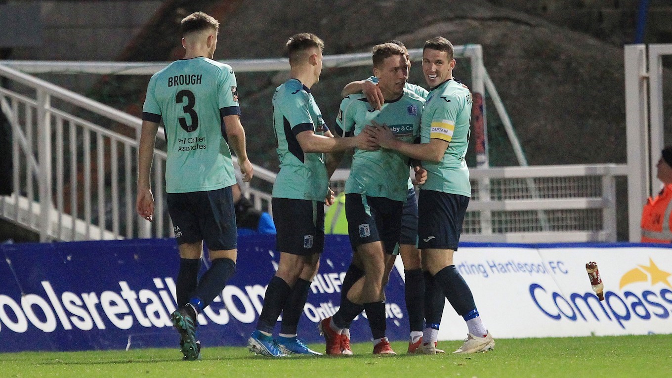 A photograph of Barrow players celebrating Lewis Hardcastle