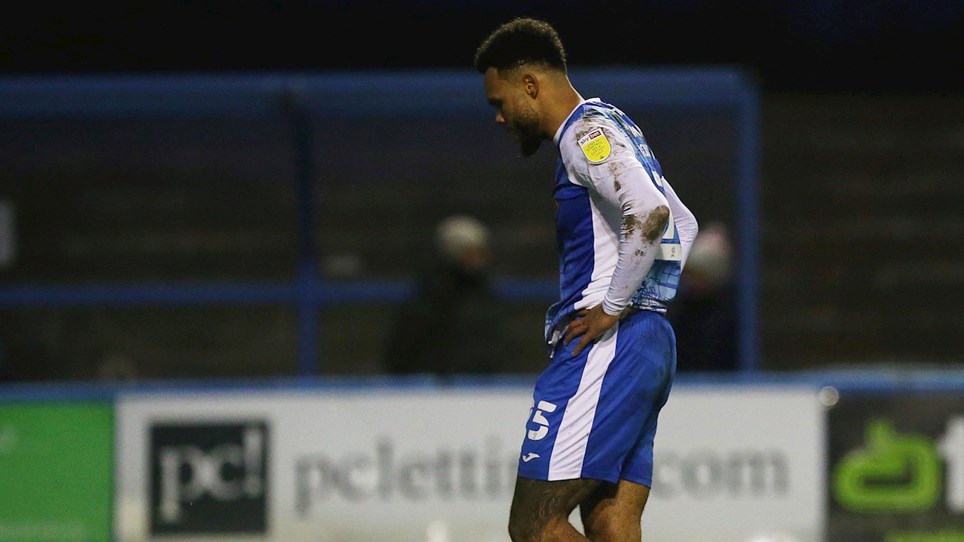 A photograph of Barrow striker Aaron Amadi-Holloway walking off after being shown a red card against Stevenage