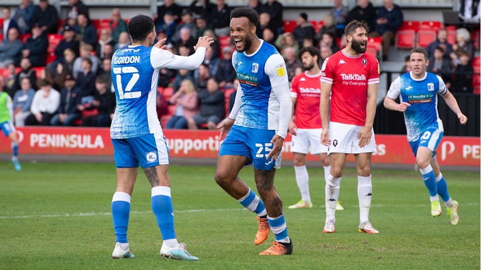 A photograph of Aaron Amadi-Holloway celebrating after scoring for Barrow at Salford City