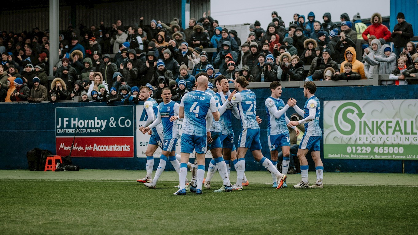 A photograph of the Barrow players celebrating a goal at The Dunes Hotel Stadium