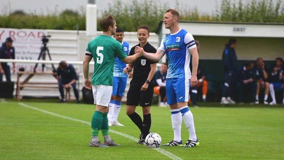 A photograph of Barrow captain Mark Ellis shaking hands with the Holker Old Boys captain before the pre-season friendly in July