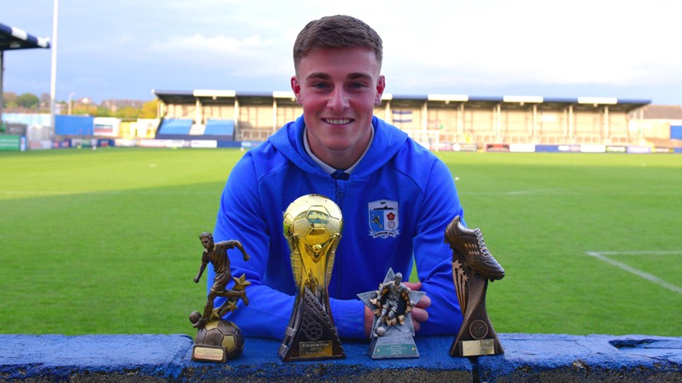 A photograph of Barrow midfielder Robbie Gotts with his Player of the Year awards
