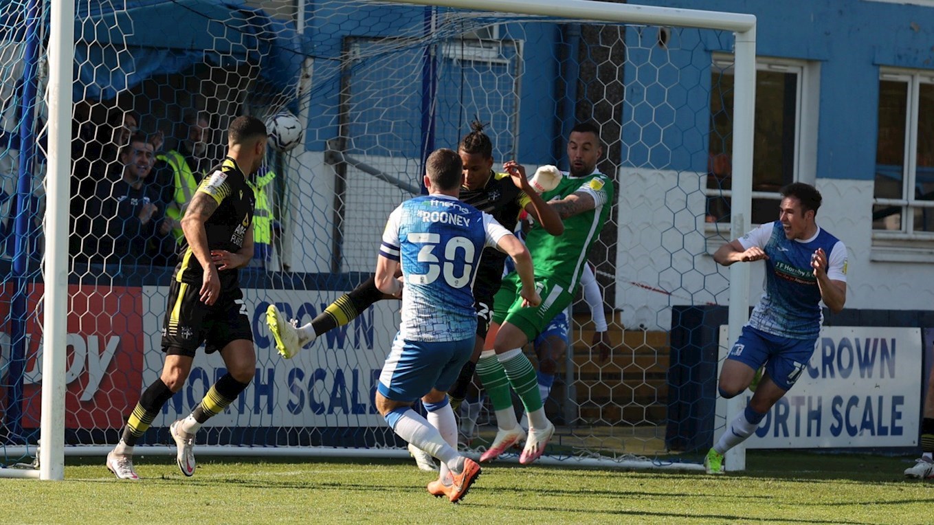 A photograph of John Rooney scoring for Barrow against Sutton United