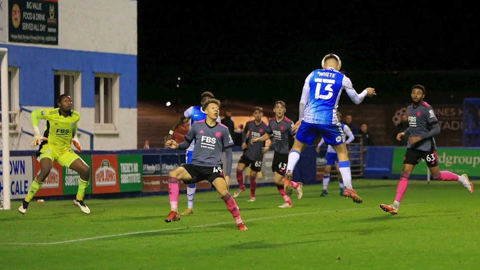 A photograph of Tom White trying a header on goal for Barrow against Leicester City Under-21s