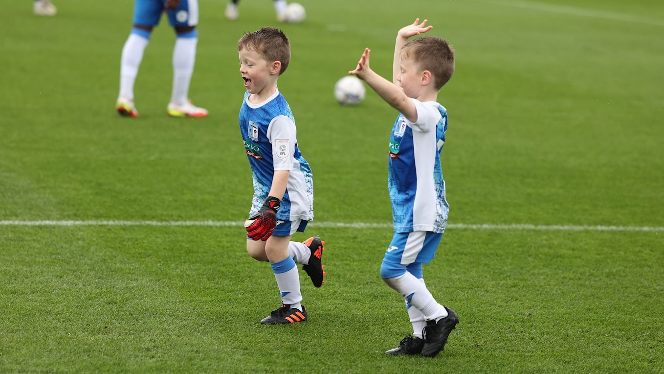 A photograph of two young Barrow fans having fun as mascots