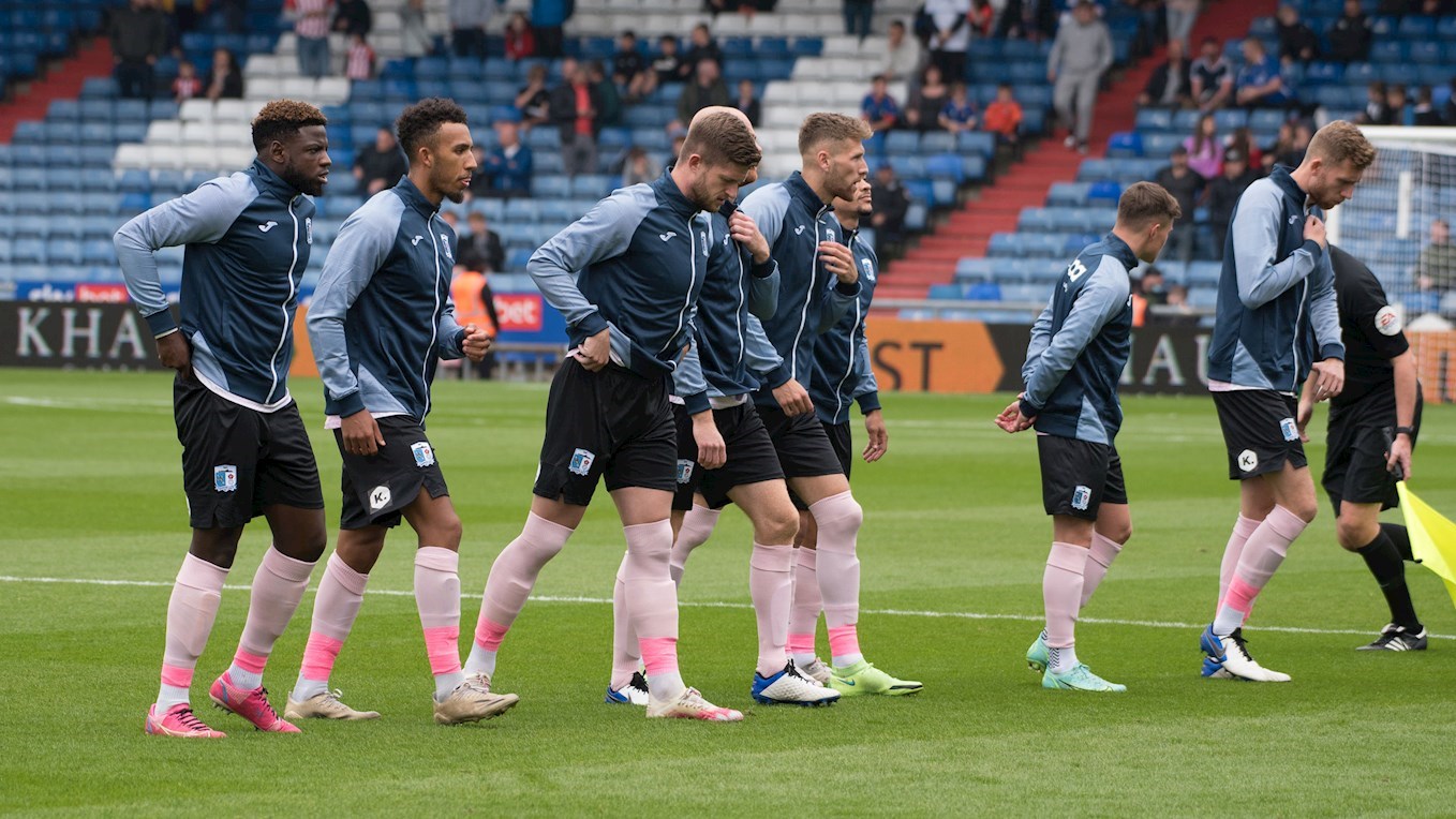 A photograph of the Barrow players in their walk-out jackets at Oldham